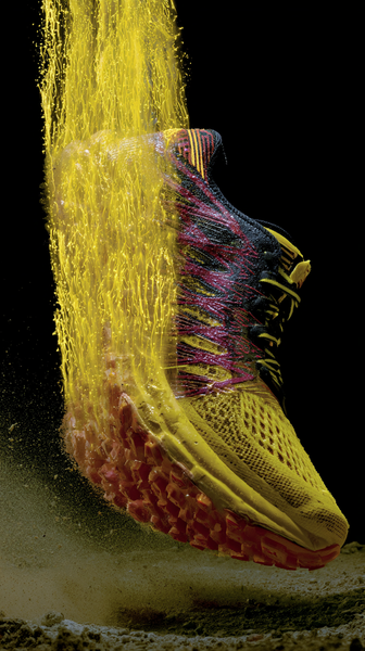 A powerful dynamic macro close-up of a high-performance running shoe in bright sun-yellow and crimson red. From its sole, a burst of glowing yellow…