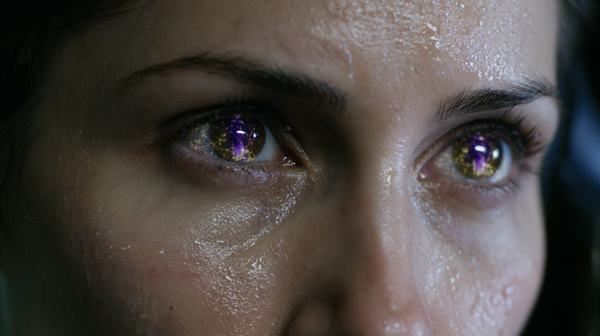 A tense, extreme close-up 16:9 vertical shot of an operative's face in a dimly lit high-rise server room. Their eyes are wide with focus, reflecting…